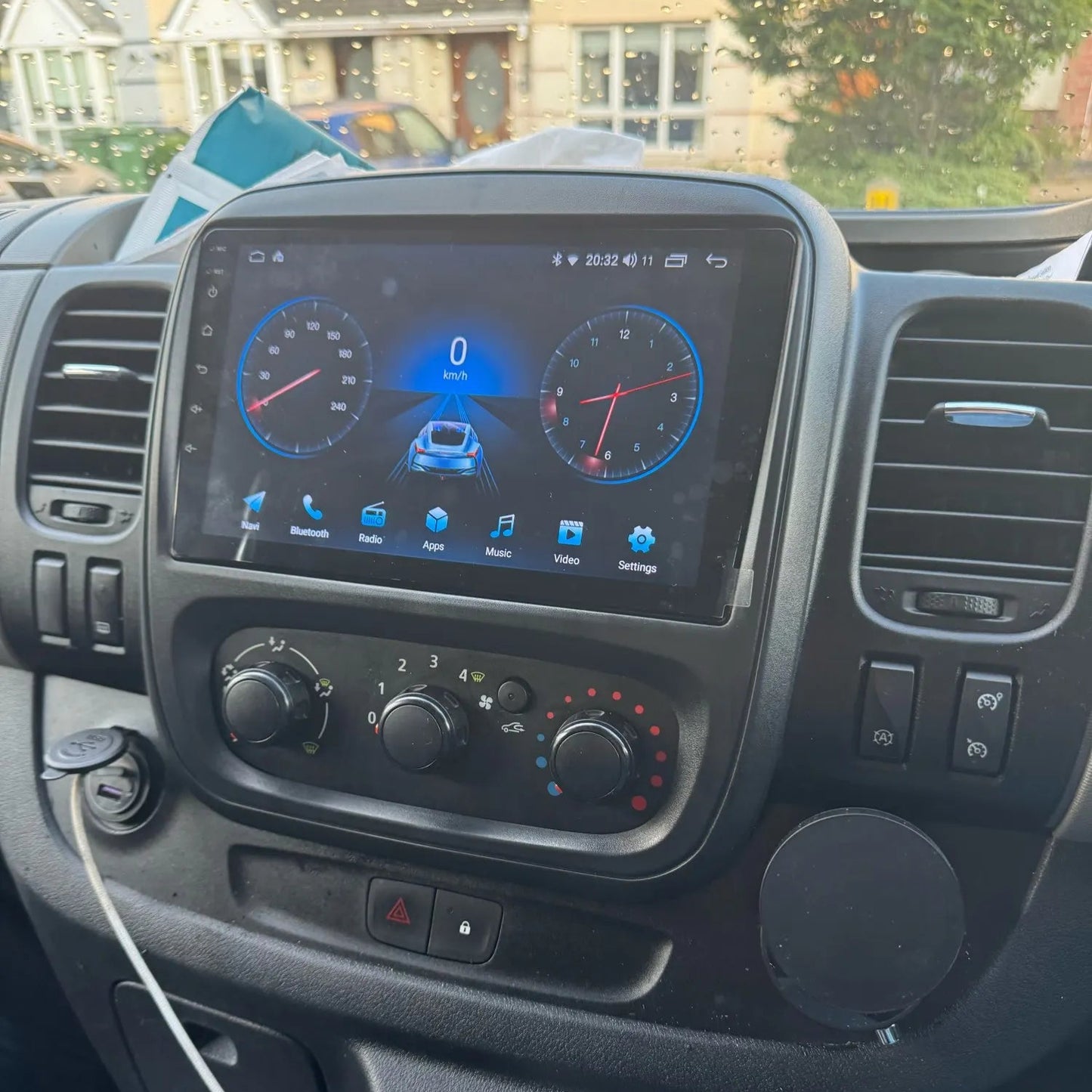 Nissan nv300 dashboard with a screen and gear shift in a residential area