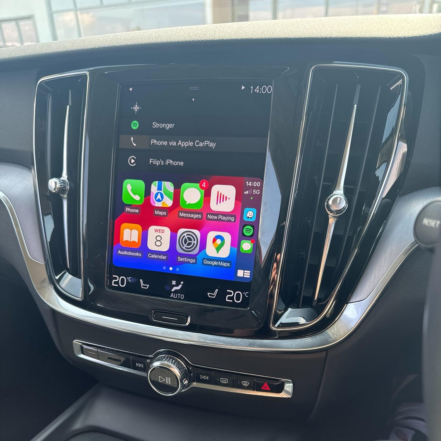 Newer Volvo interior with the vertical infotainment screen displaying the integrated wireless Apple CarPlay system.